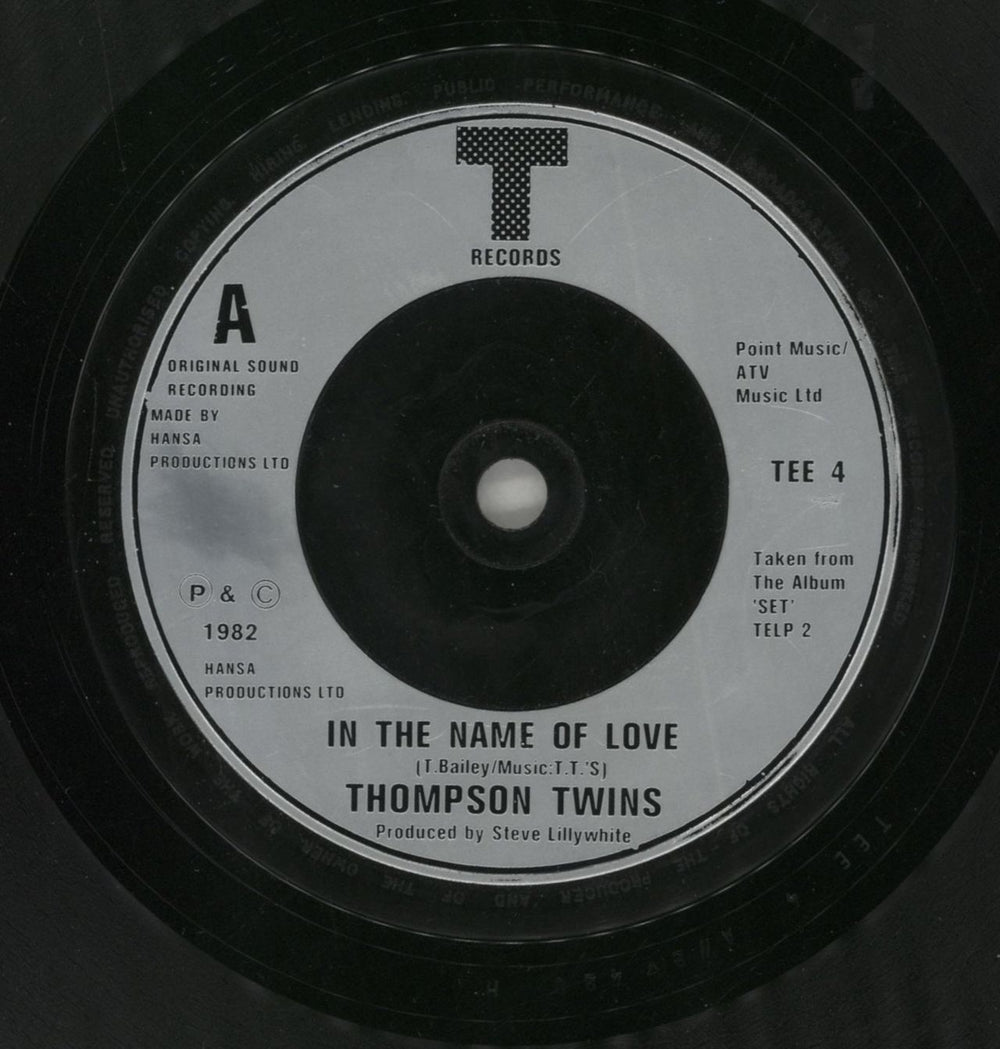 Thompson Twins In The Name Of Love + Sleeve UK 7" vinyl single (7 inch record / 45) TWI07IN179742